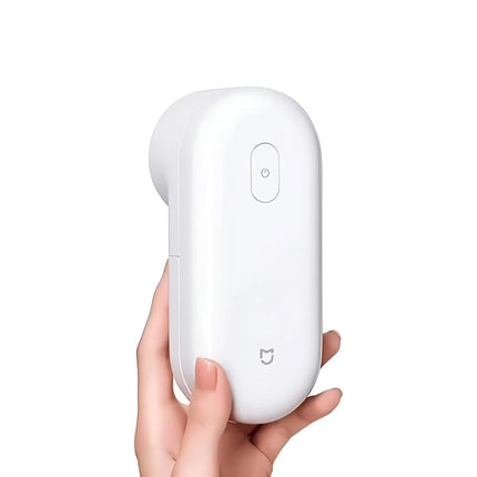 A hand holding a compact, white, rounded rectangular electronic device with a small power button on top and a small cat logo near the bottom, set against a solid white background. peetta-best online store uae