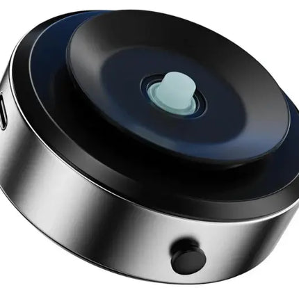 A round, metallic silver and black electronic device with a glossy black top surface, a central pale blue button, and a side USB-C port, shown on a plain white background.peetta-VacuumSuctionCarMount-MagneticUniversalPhoneHolder1