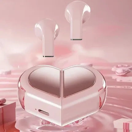 A pair of translucent pink wireless earbuds floating above a matching heart-shaped charging case on a soft pink reflective surface.Heart Shaped Wireless Earbuds Compatible with iPhone and Android UAE